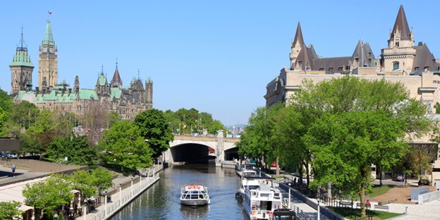 Boats docked along the Rideau Canal in downtown Ottawa on a sunny summer day