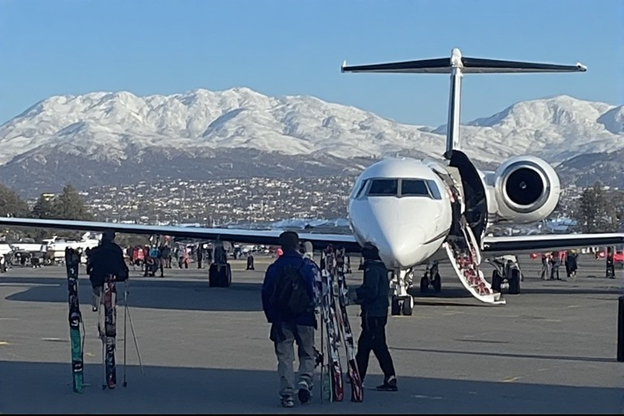 Passengers with skis exiting a private jet at Aspen, Colorado airport
