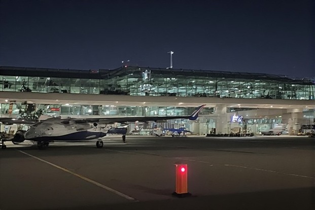 Private jet parked outside of an airport terminal at night