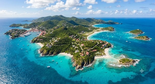 An aerial view of the St. Barts coastline featuring lush tropical islands surrounded by vibrant turquoise waters.