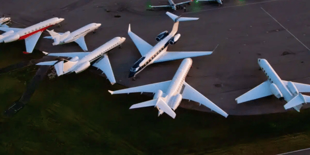 Private corporate jets parked on an airport tarmac.