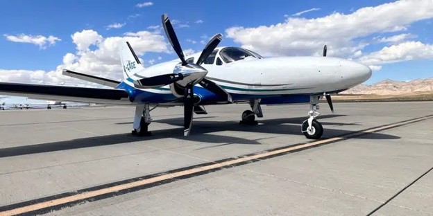 Private jet parked on a landing strip on a clear day.