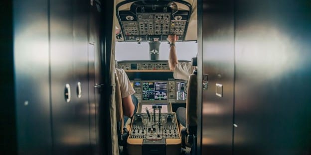 Pilot and first officer at the controls of a private jet cockpit.